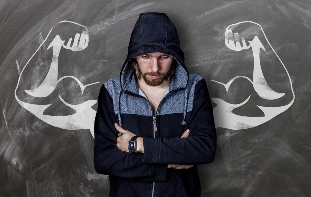 A skinny man standing in front of a chalkboard.