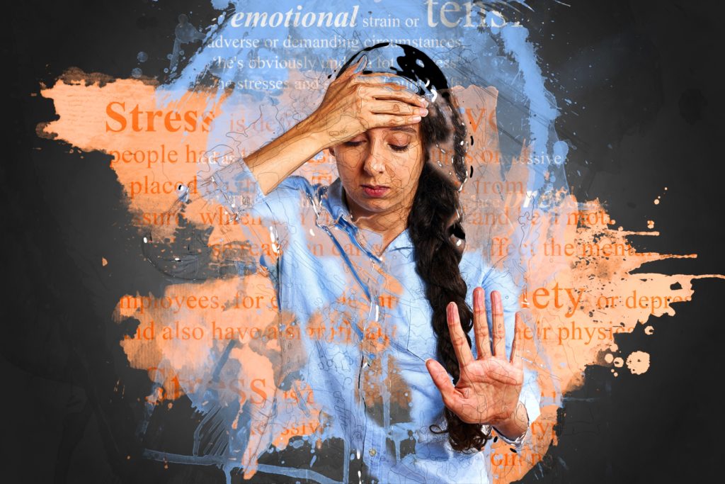 A woman looking down and putting their hand on their forehead.