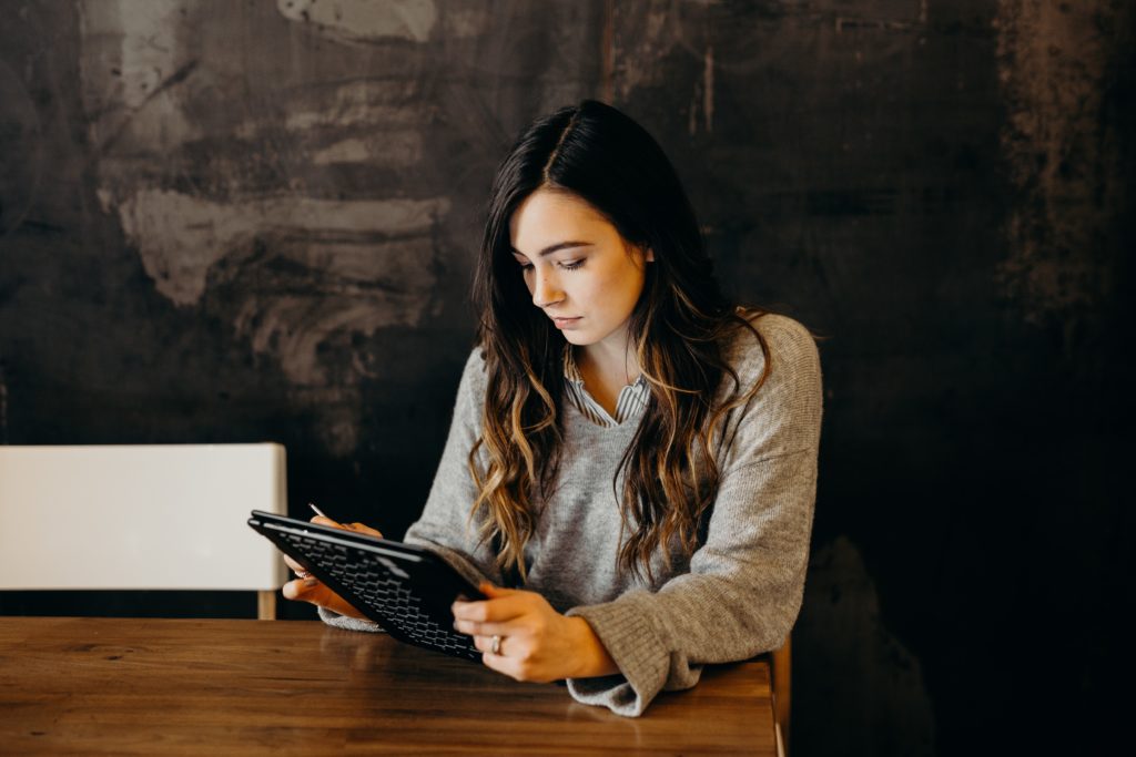 A woman holding a tablet while working remotely