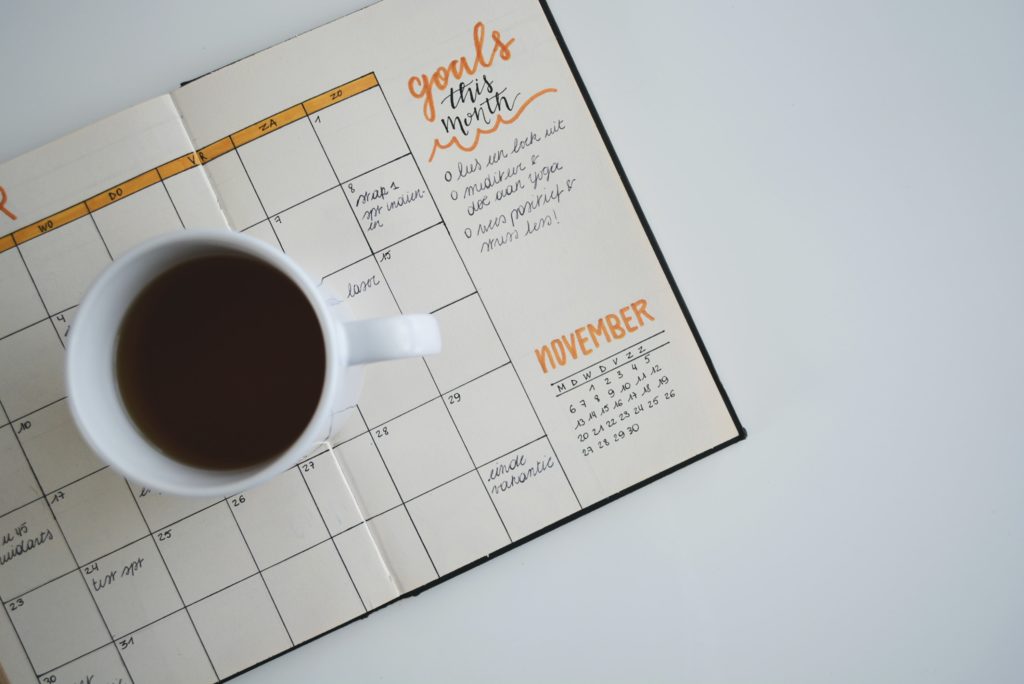 A schedule with a cup of coffee on top of it