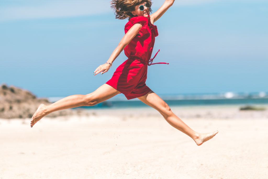 A woman jumping in the air with her legs splayed open